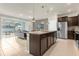 Well-lit kitchen with granite island, stainless appliances, and view into the living area and pool at 3838 Lana Ave, Davenport, FL 33897