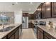 Modern kitchen featuring stainless steel appliances, granite countertops, and brown cabinetry at 3838 Lana Ave, Davenport, FL 33897