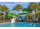 Colorful waterslides emptying into a pool surrounded by palm trees and green foliage at 3838 Lana Ave, Davenport, FL 33897