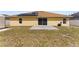 Backyard featuring solar panels, a small cement patio, and a partially-grassed lawn at 408 Magpie Ct, Kissimmee, FL 34759