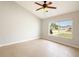Bright and airy bedroom with tile flooring, ceiling fan and a large window showcasing the neighborhood at 408 Magpie Ct, Kissimmee, FL 34759