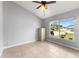 Bright bedroom featuring tile flooring, neutral paint, and a large window overlooking the manicured front lawn at 408 Magpie Ct, Kissimmee, FL 34759