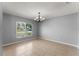 Bright dining room featuring a modern chandelier, tile floor, and view of the front yard at 408 Magpie Ct, Kissimmee, FL 34759