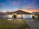 Charming yellow home with a well-manicured lawn, two-car garage, and beautifully landscaped front yard at 408 Magpie Ct, Kissimmee, FL 34759
