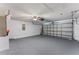 Spacious two car garage with a ceiling fan, a utility door, and painted floor at 408 Magpie Ct, Kissimmee, FL 34759