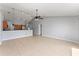 Spacious living room featuring tile flooring and a view into the eat-in kitchen with pendant lights at 408 Magpie Ct, Kissimmee, FL 34759