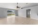 Spacious living room featuring neutral paint, tile flooring, a ceiling fan, and sliding glass doors to the backyard at 408 Magpie Ct, Kissimmee, FL 34759