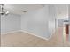 Open-concept living room features neutral tile flooring, gray walls, and a modern chandelier at 408 Magpie Ct, Kissimmee, FL 34759
