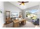 Cozy office featuring tile flooring, neutral paint, a ceiling fan, and a large window overlooking the manicured lawn at 408 Magpie Ct, Kissimmee, FL 34759