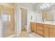 Bright bathroom featuring double vanity sinks, tiled flooring, and walk-in shower at 458 Ellis Square Ct, Sanford, FL 32771
