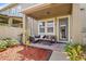 Well-lit patio with wicker furniture, a glass table, privacy fence, and mulch landscaping at 458 Ellis Square Ct, Sanford, FL 32771