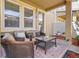 Relaxing outdoor patio with wicker furniture, a glass table, privacy fence, and manicured landscaping at 458 Ellis Square Ct, Sanford, FL 32771