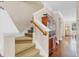 Traditional home staircase with carpet, white trim, wooden banister, and hardwood floors in foyer at 458 Ellis Square Ct, Sanford, FL 32771