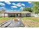 Charming backyard with a cozy fire pit, covered patio, and lush green grass at 4646 Old Road 37, Lakeland, FL 33813
