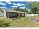 The spacious backyard features a covered patio, a manicured lawn, and a firepit at 4646 Old Road 37, Lakeland, FL 33813