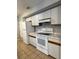 Bright kitchen with white appliances, wood-trimmed cabinets, and tile flooring at 4706 Sutton Ter # 111A2, Orlando, FL 32811