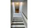 Well-lit stairwell with white risers and grey treads and handrail leading to upper level at 4706 Sutton Ter # 111A2, Orlando, FL 32811