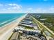 Expansive aerial view capturing the oceanfront condo complex along the coastline at 4821 Saxon Dr # 201B, New Smyrna Beach, FL 32169