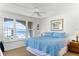 Bright bedroom with a blue patterned comforter and an ocean view from the large window at 4821 Saxon Dr # 201B, New Smyrna Beach, FL 32169