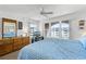 Comfortable bedroom with large windows offering exterior views, dresser and ceiling fan at 4821 Saxon Dr # 201B, New Smyrna Beach, FL 32169