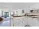 Bright kitchen with white cabinets and an island that opens to the living and dining area with water view at 4821 Saxon Dr # 201B, New Smyrna Beach, FL 32169