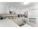 Bright kitchen features white appliances, ample counter space, and white cabinets at 4821 Saxon Dr # 201B, New Smyrna Beach, FL 32169