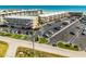 Exterior view showing a well-maintained parking lot, lush landscaping, and attractive condo buildings at 4821 Saxon Dr # 201B, New Smyrna Beach, FL 32169