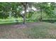 Picturesque backyard view featuring mature trees, lush green lawn, and a tranquil pond at 4917 Walden Cir, Orlando, FL 32811
