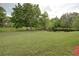 Beautiful backyard featuring lush green grass, mature trees, and a serene pond at 4917 Walden Cir, Orlando, FL 32811