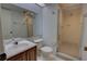 Bathroom featuring a vanity with sink, toilet, large mirror and a walk-in shower with glass door at 4917 Walden Cir, Orlando, FL 32811