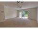 Large living room with neutral carpet, ceiling fan, and access to backyard at 4917 Walden Cir, Orlando, FL 32811