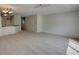 Open living room area with neutral carpet and partial view of kitchen with breakfast bar at 4917 Walden Cir, Orlando, FL 32811