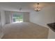 Spacious living room featuring neutral carpet, ceiling fan, and sliding glass doors to backyard at 4917 Walden Cir, Orlando, FL 32811