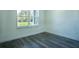 Bright bedroom featuring gray laminate flooring and a window showcasing the outdoor view at 5 Fisher Loop, Ocklawaha, FL 32179