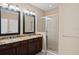 Bathroom featuring granite countertops, dual sinks, a glass-enclosed shower, and dark wooden cabinets at 5412 Factors Walk Dr, Sanford, FL 32771