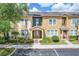 Inviting townhome featuring a beige exterior, manicured landscaping, and an American flag waving near the entrance at 5412 Factors Walk Dr, Sanford, FL 32771