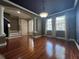 Spacious living room with hardwood floors, large windows, columns and stylish lighting fixture at 5412 Factors Walk Dr, Sanford, FL 32771