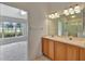 Bathroom with a double sink wooden vanity, tile flooring, and a view into another room with a shower at 602 Westview Dr, Minneola, FL 34715