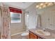 Cozy bathroom with a tub, shower, toilet, wooden vanity and a window covered by a curtain at 602 Westview Dr, Minneola, FL 34715