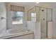 Bright bathroom featuring a soaking tub, glass shower, and a window providing natural light at 602 Westview Dr, Minneola, FL 34715