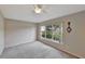 Cozy bedroom showcasing neutral walls, a ceiling fan, and a large window providing natural light and outdoor views at 602 Westview Dr, Minneola, FL 34715