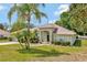 Inviting home with tropical landscaping, lush green lawn, and neutral exterior paint at 602 Westview Dr, Minneola, FL 34715