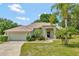 Charming single-story home with a well-manicured lawn, mature palm trees, and attached two-car garage at 602 Westview Dr, Minneola, FL 34715