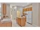 Bright kitchen features wooden cabinets, white appliances, and an island for food preparation and storage at 602 Westview Dr, Minneola, FL 34715