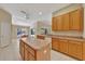 Bright kitchen boasts wood cabinets, central island, and seamless flow into a sunlit dining area, creating an inviting space at 602 Westview Dr, Minneola, FL 34715