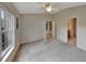 Spacious main bedroom featuring neutral carpet, a ceiling fan, and doorways leading to a bathroom and a closet at 602 Westview Dr, Minneola, FL 34715