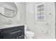 Bright bathroom featuring a dark vanity, marble countertop, modern finishes and a round mirror above the sink at 621 Ashberry Ln, Altamonte Springs, FL 32714