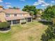 Backyard featuring screened in lanai, mature landscaping and green lawn at 6240 Miramonte Dr # 102, Orlando, FL 32835