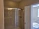 Glass-enclosed shower with tiled walls and an adjacent door to the bedroom at 6240 Miramonte Dr # 102, Orlando, FL 32835