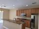 Spacious kitchen featuring stainless steel appliances and a granite-topped island for casual dining at 6240 Miramonte Dr # 102, Orlando, FL 32835